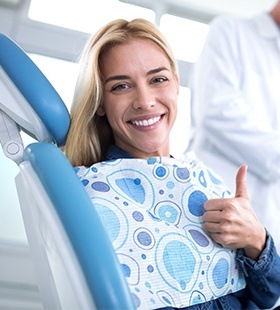 Smiling in dental chair giving thumbs up