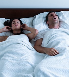 Man snoring while in bed with his spouse