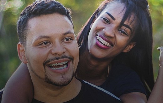 Young man and woman smiling outdoors