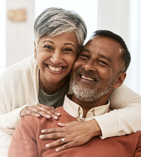 Happy couple living with ceramic dental implants