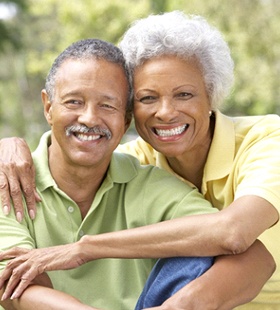 An older couple smiling and hugging