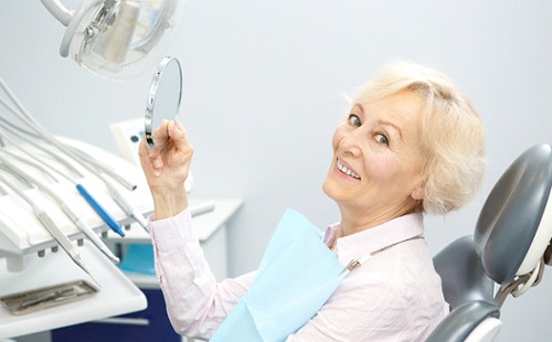 An older woman smiling and pleased after receiving her dentures in Delafield