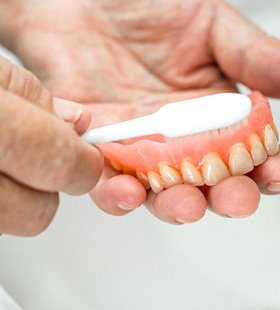 patient brushing their dentures