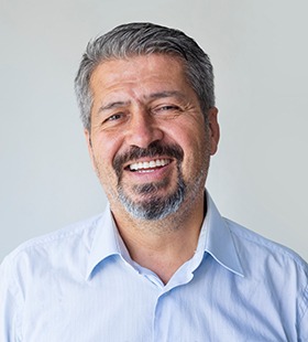 Middle-aged man wearing dentures and smiling