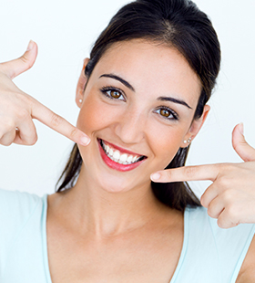 Woman pointing to her beautiful healthy smile