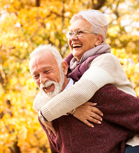 An older couple smiling and having fun outside