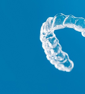 Person holding an Invisalign aligner