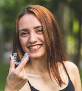 Young woman holding Invisalign aligner in Delafield