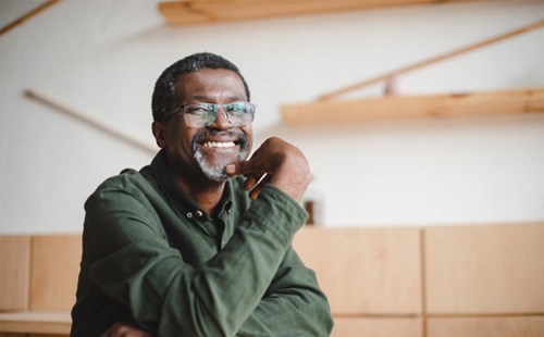 Older man with glass smiling after receiving NightLase® Snoring Treatment in Delafield 