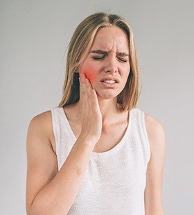 Woman in pain holding cheek