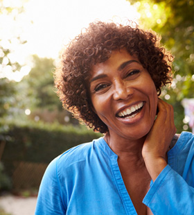 Middle-aged woman smiling and pleased with her oral health 