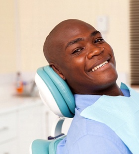 A young male seated in a dentist’s chair and preparing to receive naturopathic medicine