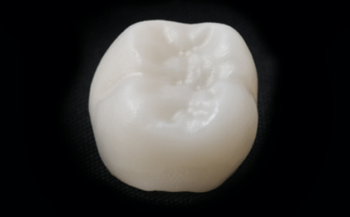 White ceramic dental crown on a black background