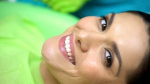 a woman smiling in the dentist chair