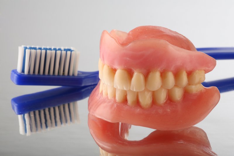 full dentures and a toothbrush